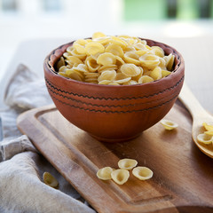 Raw  pasta orecchiette in a ceramic bowl 