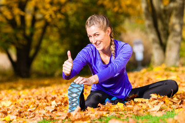 Sportswoman sport stretching in autumn leaves