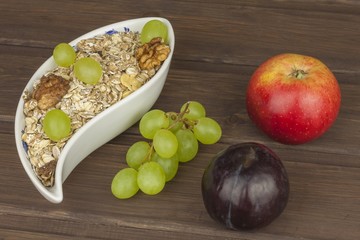 Healthy Diet breakfast of oatmeal, cereal and fruit. Foods full of energy for athletes. The concept of diet food. Preparing homemade breakfast. Vegetarian diet. Food on a wooden table.


