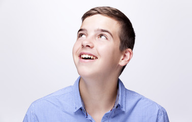 Daydreaming boy looking up against grey background