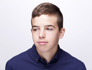 Fototapeta premium Teen boy looking sad on grey background