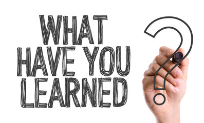 Hand with marker writing: What Have You Learned?