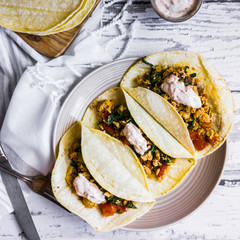 Tacos with chicken and vegetables on white wooden background