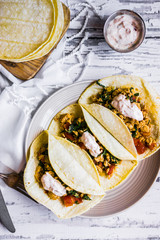 Tacos with chicken and vegetables on white wooden background