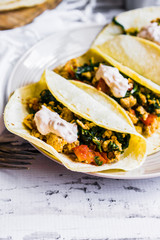 Tacos with chicken and vegetables on white wooden background