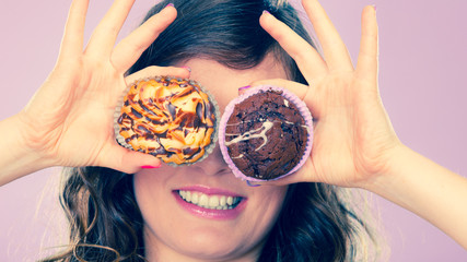 Smiling crazy woman holds cakes in hand