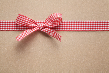 Ribbon bow on paper textured background