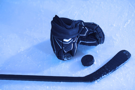 hockey sticsk and puck on ice