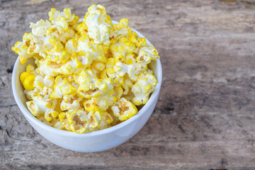Popcorn in glass bowl on old wood background