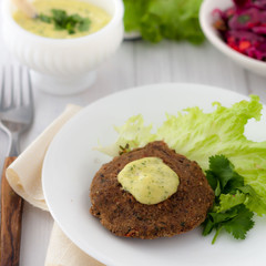 bean burger without a bun served on a plate with aioli sauce