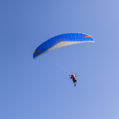 Paraglider isolated on blue sky