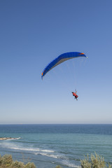Fototapeta na wymiar Paraglider hovers above the sea