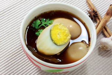 stewed eggs or eggs and pork in brown sauce by Thai food .