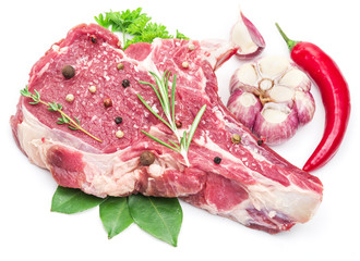 Raw beef meat steak with spices on the white background.