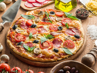Pizza with mushrooms, salami and tomatoes.