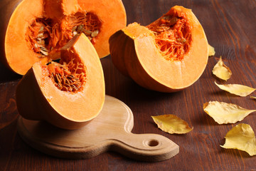 pumpkin cut with leaves on chalkboard on wooden background