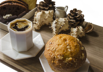 Black coffee in a white cup with cupcakes