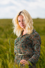Attractive young blonde woman in rye field grass