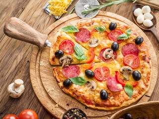 Pizza with mushrooms, salami and tomatoes.