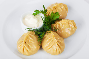 manti parsley with sour cream and dill on a white background
