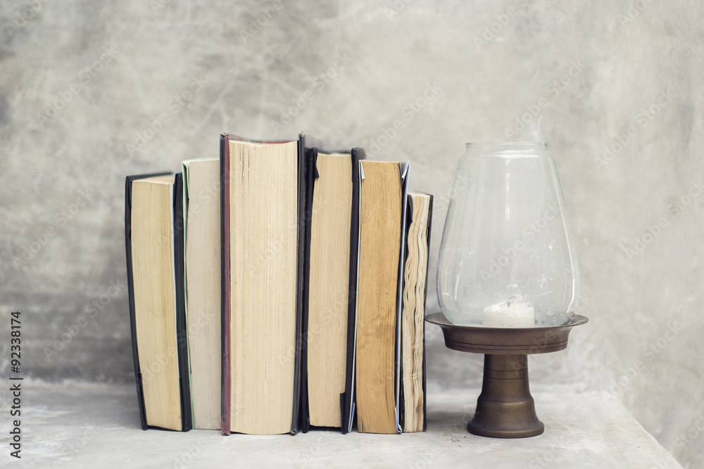 Poster stack of books on the shelf and near the lamp