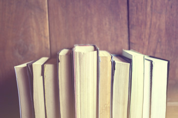 Books on a wooden background, vintage color effect