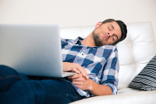 Man sleeping with laptop on the sofa