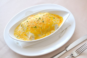 Lasagna in a white dish on a black table.
