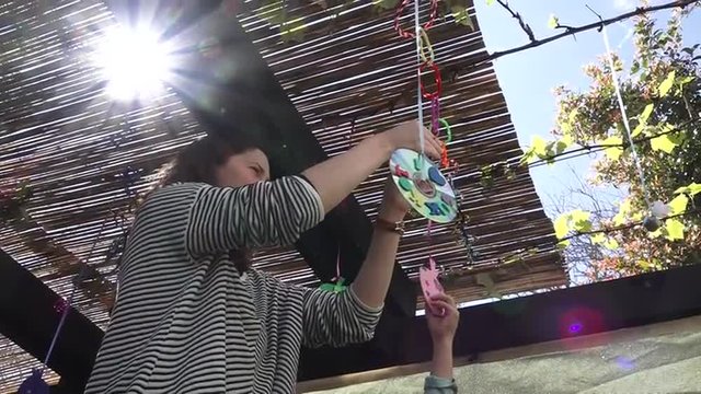 Jewish woman and child decorating their family Sukkah for the Jewish festival of Sukko