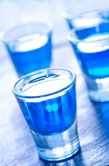 blue alcoholic drink into small glasses