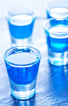 Blue Alcoholic Drink Into Small Glasses