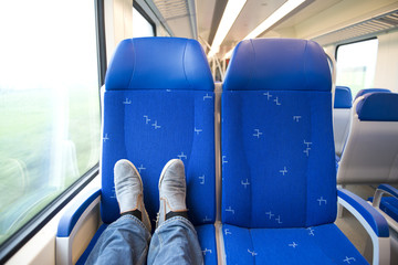 Traveling alone in a trein, feet on the seats