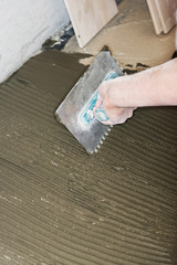 Tiler installs ceramic tiles