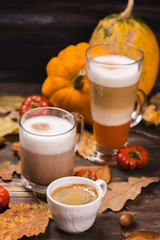 Autumn hot coffee drinks. Pumpkin latte, hot chocolate and espresso on wooden rustic background. Selective focus