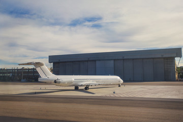 Twin jet aircraft in front of a large hangar