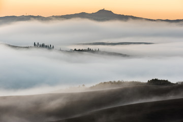Beautiful foggy landscape in the middle sunrise. Italy, Tuscany.