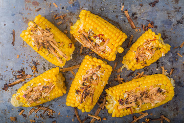 Roasted sweet corn on the cob on metal background