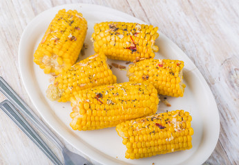 Roasted sweet corn on the cob on white plate