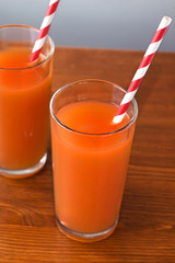 Orange juice glass and fresh oranges on wood