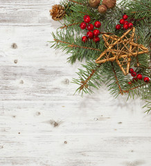 Fototapeta na wymiar Fir branch with Christmas decorations on the white wooden plank.