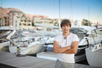 Fototapeta na wymiar Handsome man by luxury yacht background on the beach at sunset.