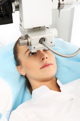 Klinika okulistyczna, laserowa korekcja wzroku. Pacjentka  na sali operacyjnej podczas zabiegu chirurgii okulistycznej - obrazy, fototapety, plakaty