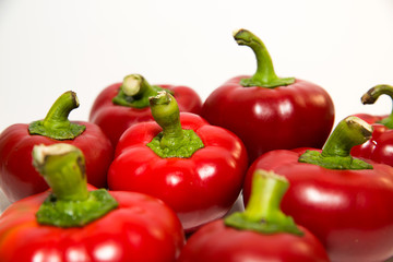 Many ripe red peppers on over white