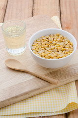 Healthy golden soil oil with a cup of raw soybean