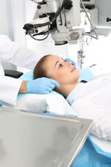 Klinika okulistyczna.Pacjentka  na sali operacyjnej podczas zabiegu chirurgii okulistycznej - obrazy, fototapety, plakaty