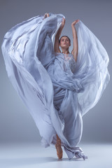 Obraz premium The beautiful ballerina dancing in blue long dress 