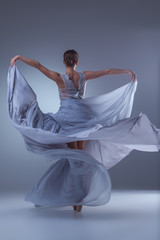 Fototapeta premium The beautiful ballerina dancing in blue long dress 
