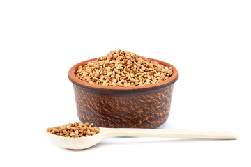 Buckwheat in a ceramic bowl and a wooden spoon.
