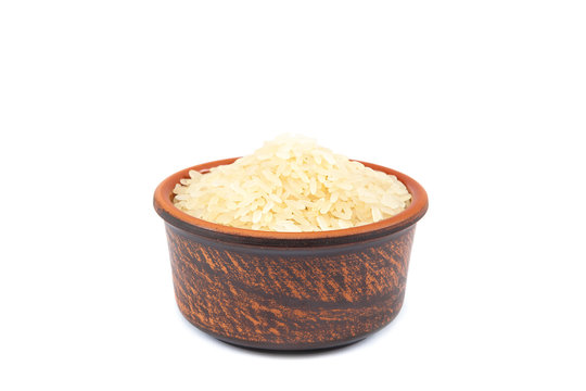 Rice groats in a ceramic bowl on white background.