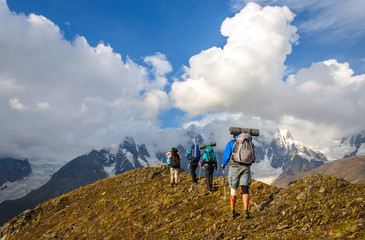 Group of tourists with large backpacks are on mountain
